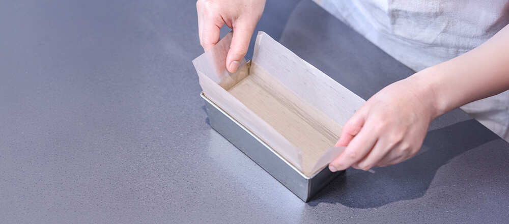 パウンド型にシートを入れる瞬間のカット